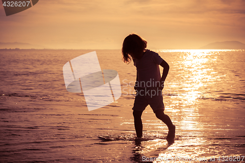 Image of Happy little boy standing on the beach 