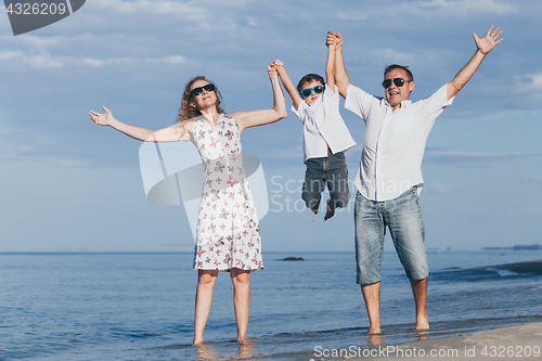 Image of Happy family walking on the beach at the day time.