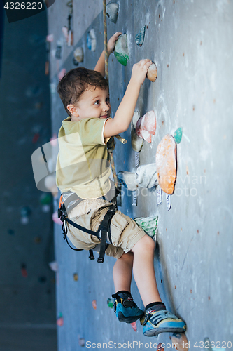 Image of little boy climbing a rock wall indoor