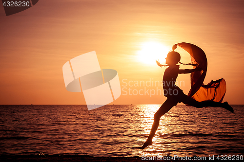 Image of Happy girl jumping on the beach