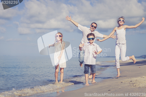 Image of Father and children playing on the beach at the day time. 