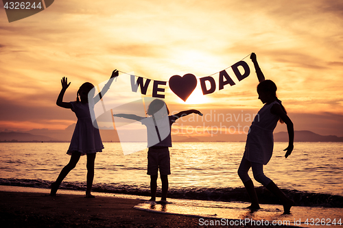 Image of Happy children playing on the beach at the sunset time. 