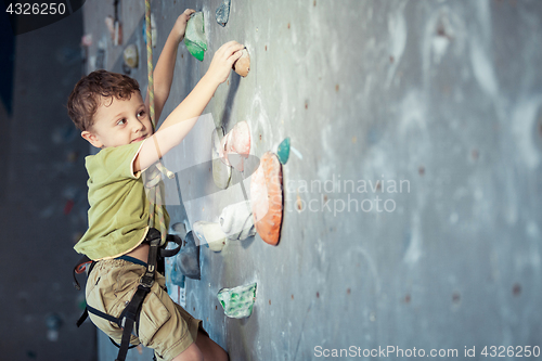 Image of little boy climbing a rock wall indoor