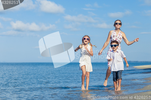 Image of Mother and children playing on the beach at the day time.