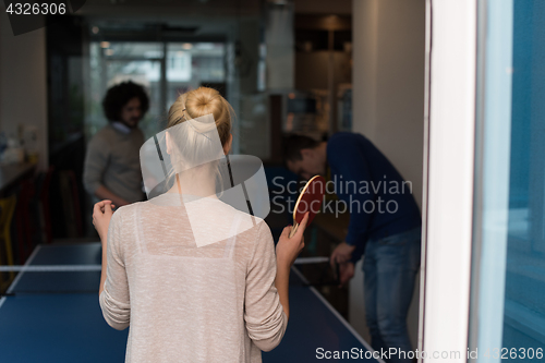 Image of startup business team playing ping pong tennis