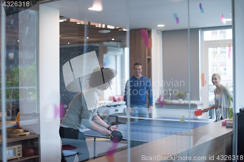 Image of startup business team playing ping pong tennis