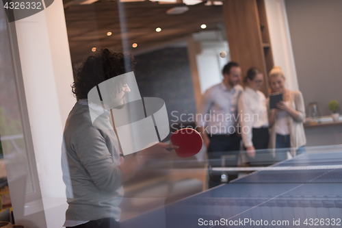 Image of startup business team playing ping pong tennis