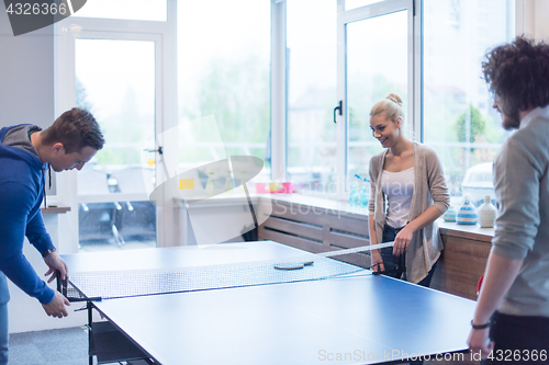 Image of startup business team playing ping pong tennis