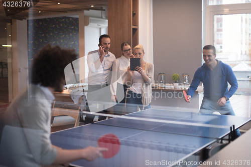 Image of startup business team playing ping pong tennis