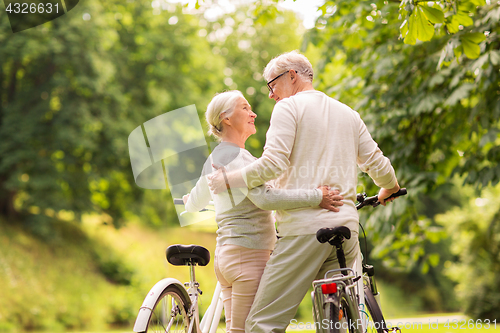 Image of happy senior couple with bicycles at summer park