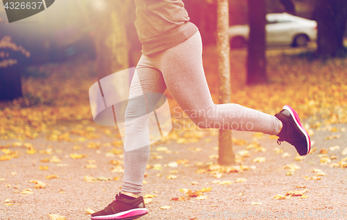 Image of close up of young woman running in autumn park