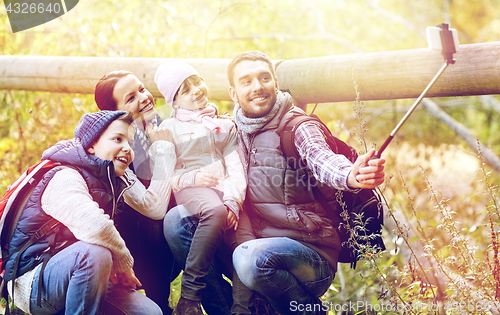 Image of happy family with smartphone selfie stick in woods