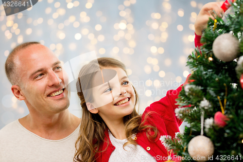 Image of father and daughter decorating christmas tree