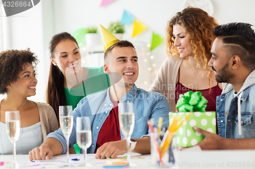 Image of team greeting colleague at office birthday party