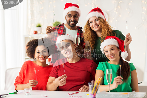 Image of happy team celebrating christmas at office party