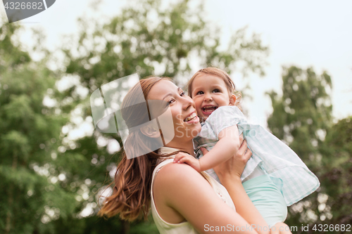 Image of happy mother holding baby girl at summer park