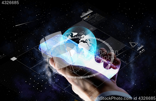 Image of hand with smartphone and earth projection
