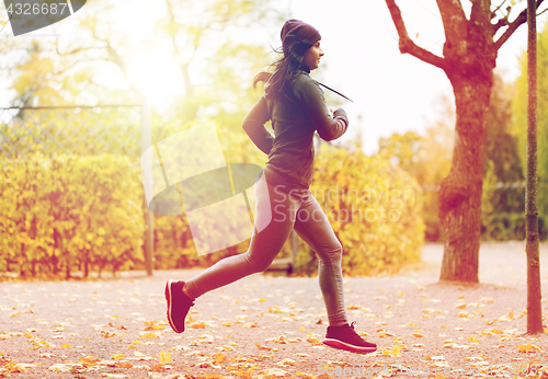 Image of close up of young woman running in autumn park