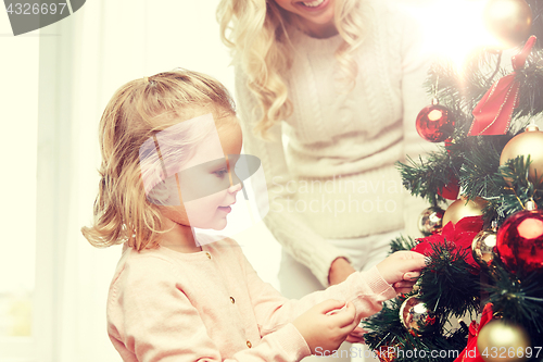 Image of happy family decorating christmas tree at home