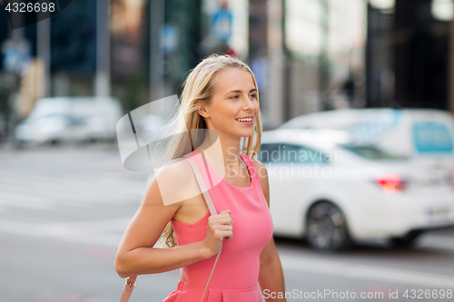 Image of happy smiling young woman on city street
