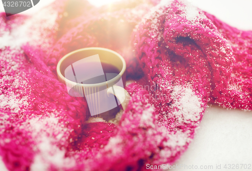 Image of close up of tea or coffee and winter scarf in snow