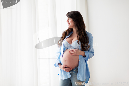Image of happy pregnant woman with big tummy at home