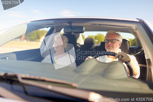 Image of happy senior couple driving in car