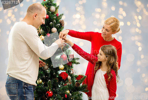 Image of mother, father and daughter at christmas tree