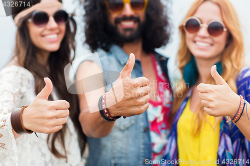 Image of happy young hippie friends showing thumbs up