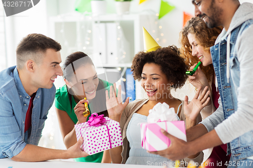 Image of team greeting colleague at office birthday party