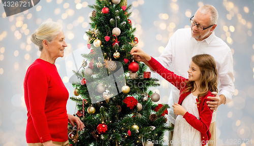 Image of grandparents and granddaughter at christmas tree