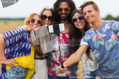 Image of hippie friends with smartphone and selfie stick