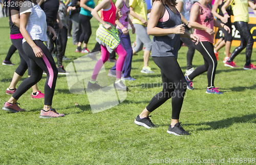 Image of Group of young girls exercising fitness with dancing in the city