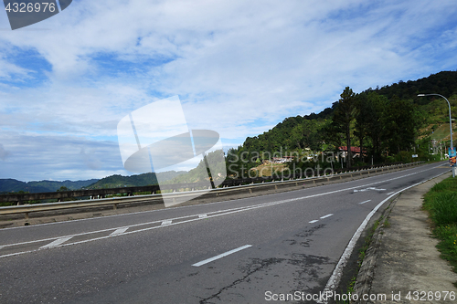 Image of Road into hills with blue sky at Sabah