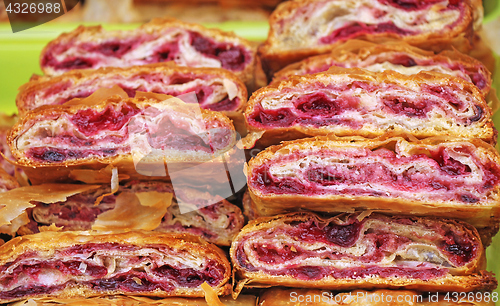 Image of Sliced homemade strudel with cherry in streat market