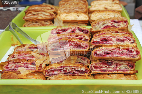 Image of Sliced homemade strudel with cherry in streat market