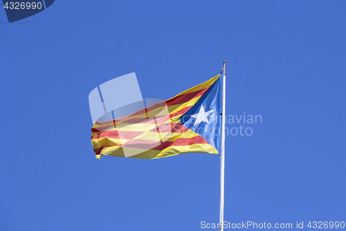 Image of Catalan flag on the wind in blue sky