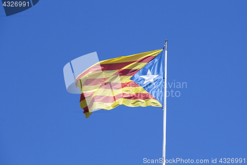 Image of Catalan flag on the wind in blue sky