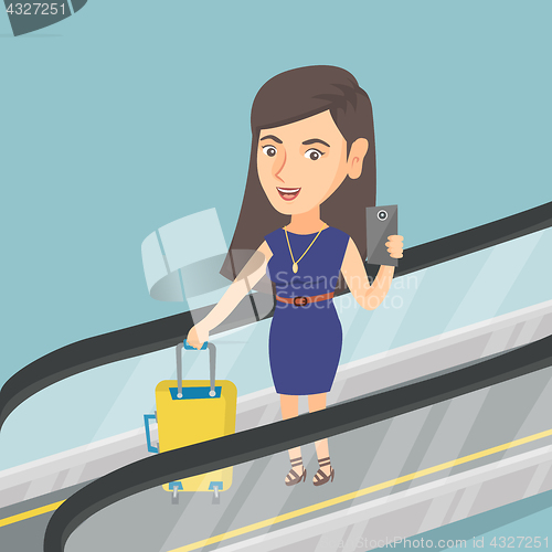 Image of Woman using smartphone on escalator at the airport