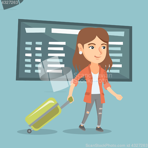 Image of Caucasian woman walking with suitcase at airport.