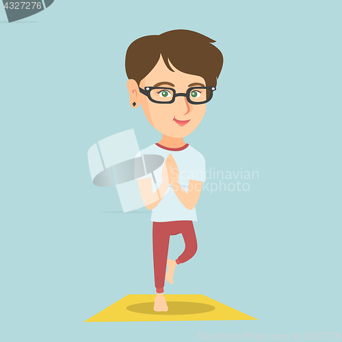 Image of Young caucasian woman practicing yoga tree pose.