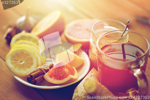 Image of ginger tea with honey, citrus and garlic on wood