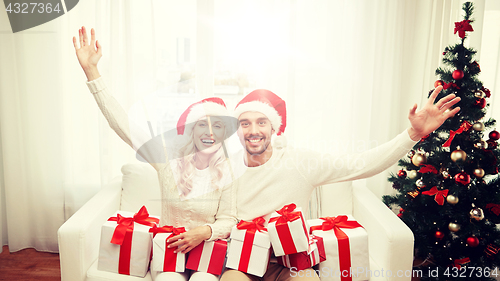 Image of happy couple at home with christmas gift boxes