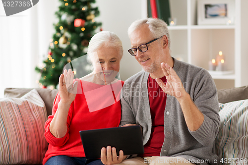 Image of happy senior couple with tablet pc at christmas