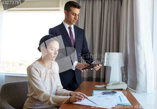 Image of business team with papers working at hotel room