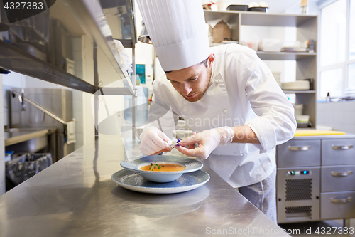 Image of happy male chef cooking food at restaurant kitchen