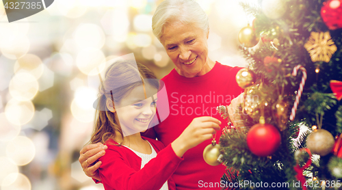 Image of grandmother and granddaughter at christmas tree