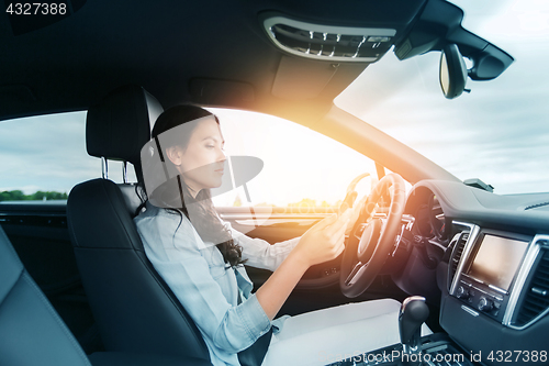 Image of woman driving car with smarhphone