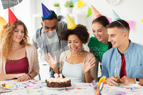 Image of team greeting colleague at office birthday party