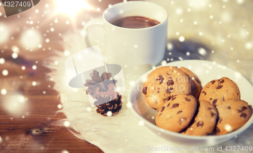 Image of cups of hot chocolate with cookies on fur rug